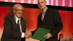 Mauri Kostiainen sai palkinnon WCC:n puheenjohtajalta, nobelisti Edmond H. Fischeriltä.
