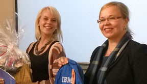 Laura Toivola sai IBM:n  yliopisto- ja yhteiskuntasuhteista vastaavalta johtajalta Maarit Palolta onnittelukukat sekä tapahtuman teemaan liittyen repun ja ruokakorin.