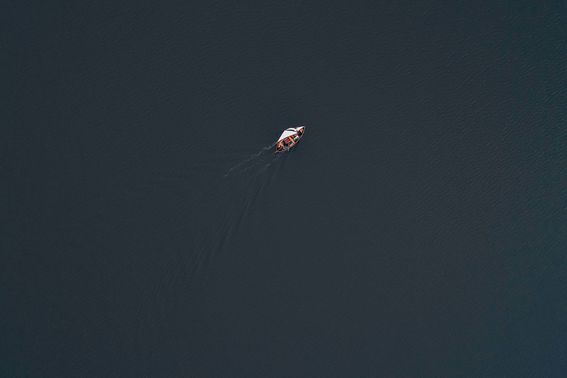 A sailing boat at sea, shot from above in the air