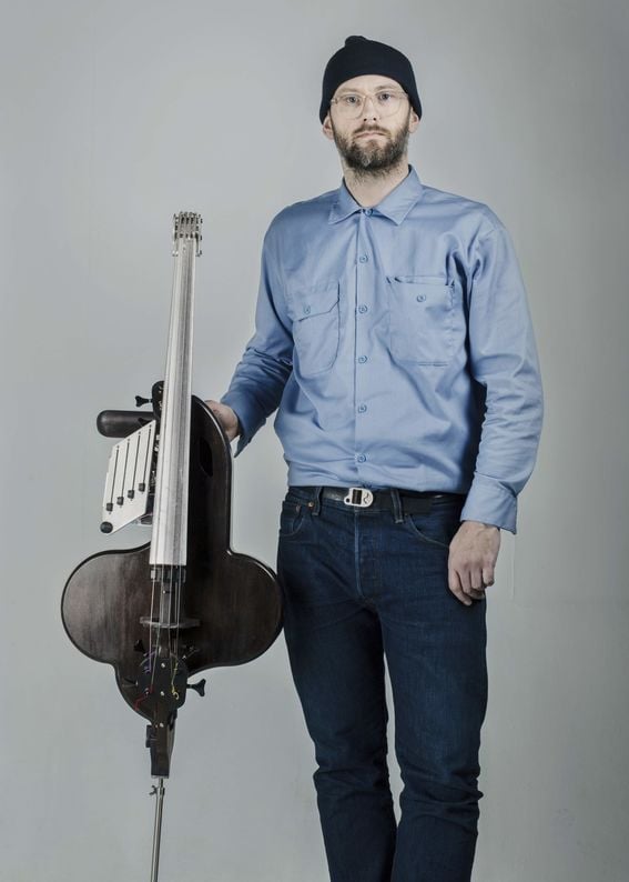 Muotoilija Halldór Úlfarsson pitelee suunnittelemaansa selloa muistuttavaa elektroakustista soitinta, halldorophonea.