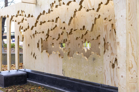 A slanted view of the plywood artpiece reveals the multiple layers of plywood.