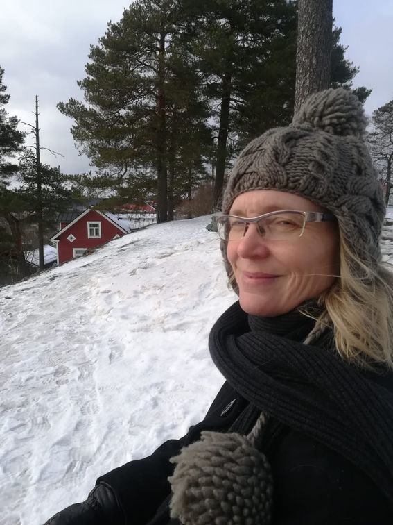 Hymyilevä nainen villapipo päässä lumisessa maisemassa Pispalan harjulla Tampereella