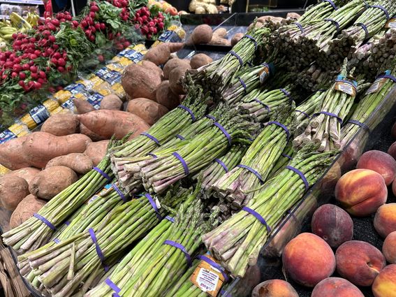 Kuvassa näkyy vihanneksia ja hedelmiä kaupan tiskillä. 