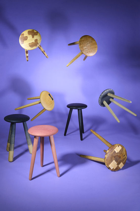 different designs of chairs photographed in a studio with a purple background