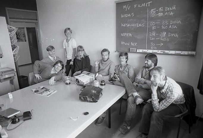 people posing at table in black and white