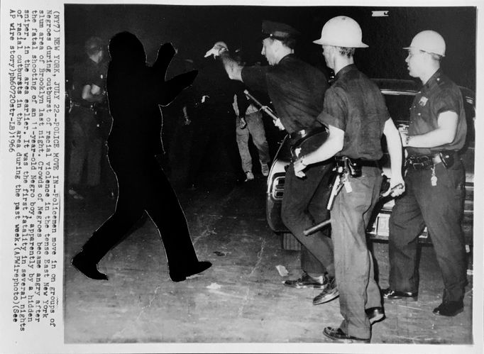 Balck and white archive picture of Three police officers charging at a protestor
