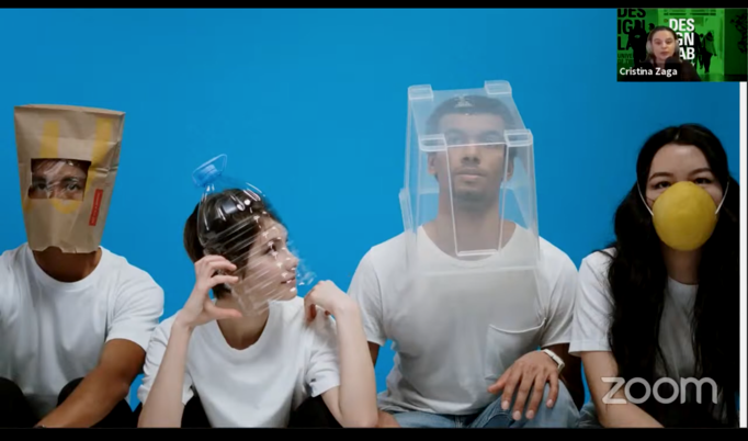 Slide from Cristina Zaga's zoom presentation. It shows a photograph of four individuals in white t-shirts sat against a cyan background. They each wear a different type of head protection made from everyday items.