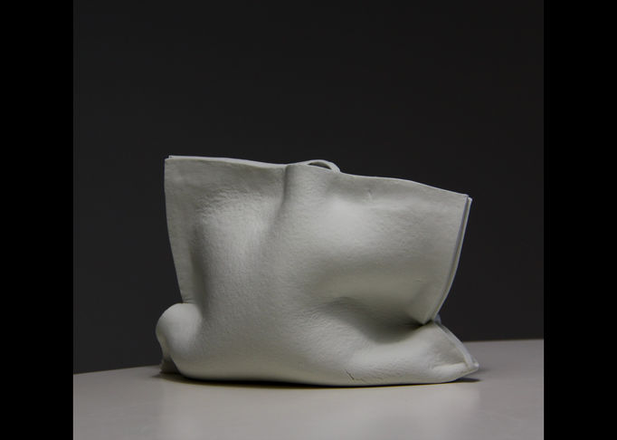a white ceramic bag-like vase