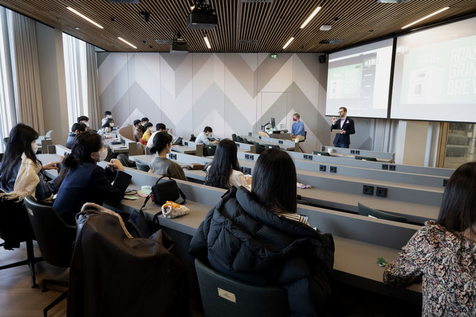 A group of students from UNISt university listening to a lecture in Ecosystems in business by Esko Hakanen at Aalto University School of Business.