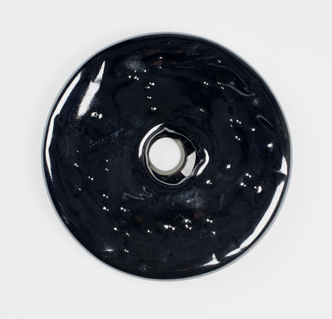 almost black-coloured round glass piece with a hole in the middle
