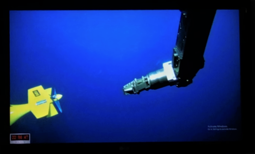 Remotely operated vessel reaches for AUV underwater