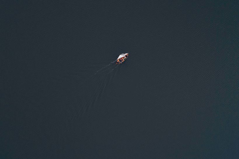A sailing boat at sea, shot from above in the air