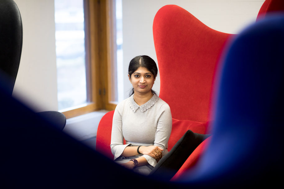 Nagadivya Balasubramaniam sitting on a red armchair