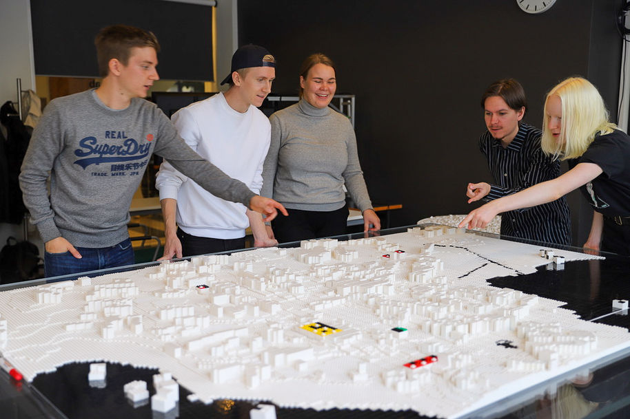 Opiskelijat legoista rakennetun Otaniemi-mallin ympärillä