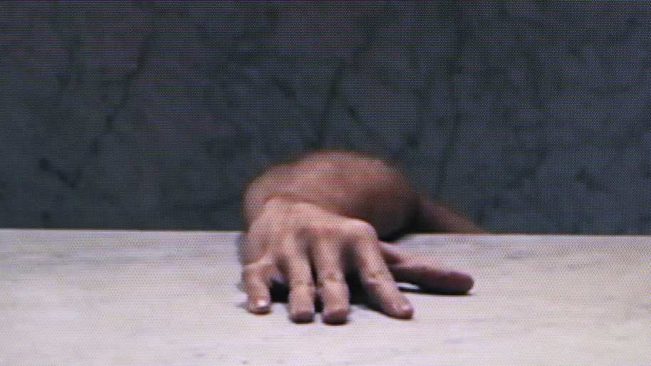 A still from the video art work portraying a hand of somebody hiding from the audience's gaze