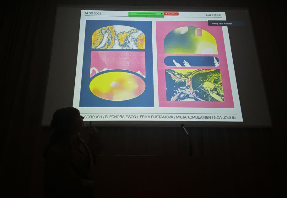 Eleonora citing her poem in front of a colourful slideshow