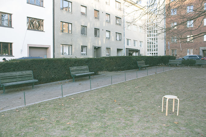 A stool in front of a cluster of residential buildings