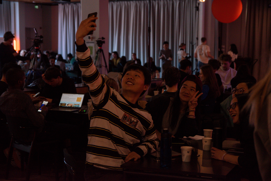 Henkilö ottaa selfietä tiiminsä kanssa hackathonissa