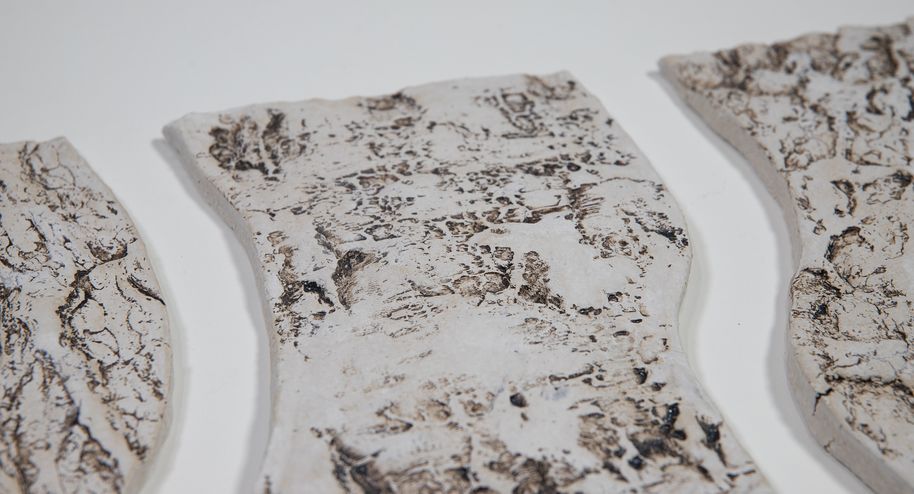 Close up of a white, bark textured ceramic piece