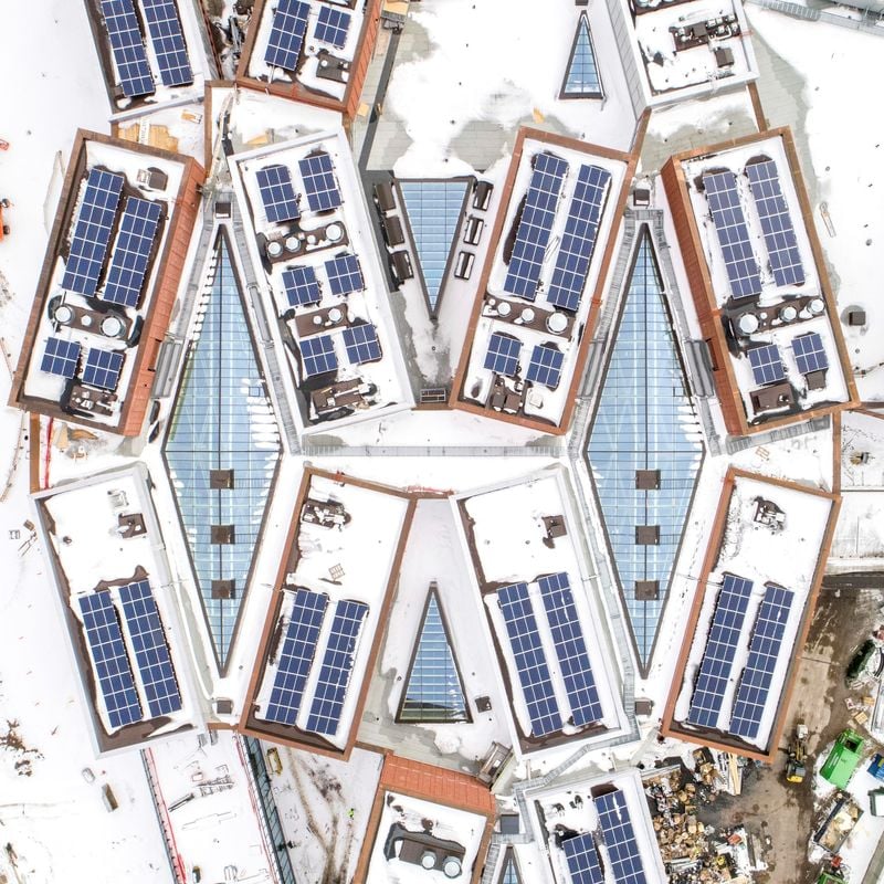 Aerial view in winter of Väre and School of Business buildings during contruction, solar panels in view