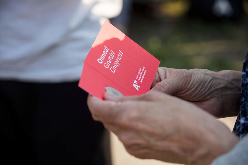 A red greeting card with 'Congrats' written on it for the new alumni of Aalto University. 