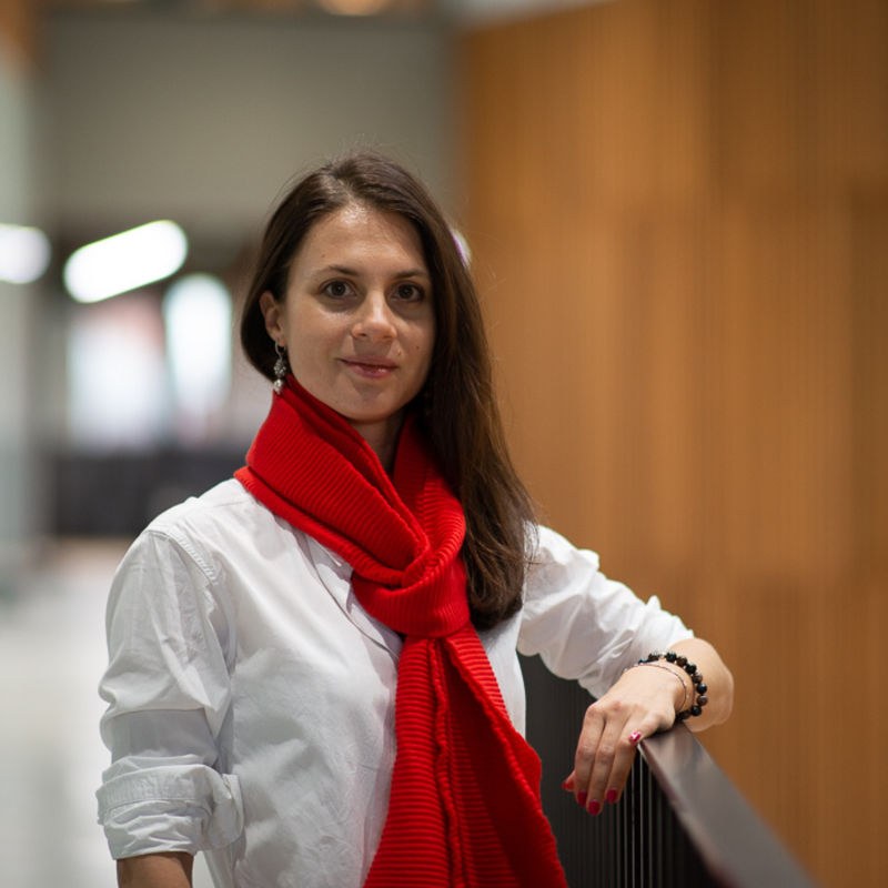Picture of Lidia Borisova She is wearing a white shirt and red scarf and is smiling towards the camera.
